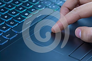 Man using touchpad on notebook keyboard with his finger