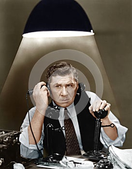 Man using two telephones