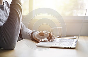 A man using and typing keyboard of laptop computer communicates on internet technology