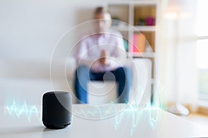 Man using virtual assistant, smart speaker at home photo