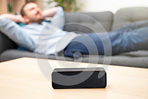 Man using virtual assistant and smart speaker at home