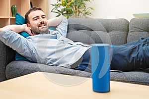 Man using virtual assistant and smart speaker at home