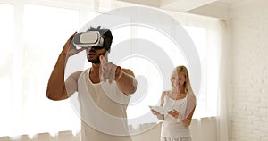 Man using virtual reality glasses woman holding digital tablet computer 3d technology concept, mix race couple home play