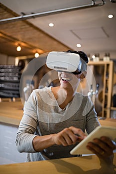 Man using virtual reality headset and digital tablet in restaurant
