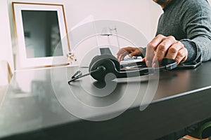 Man using VOIP headset with latop computer on desk in modern off