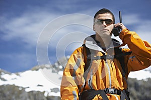 Man Using Walkie Talkie Against Mountain