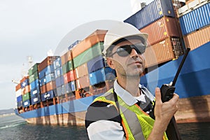 Man Using Walkie Talkie At Container Terminal photo