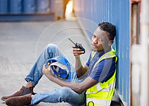 Man Using Walkie Talkie At Container Terminal, Industrial worker is controlling container loading