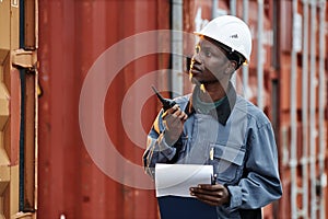 Man using walkie talkie at shipping docks