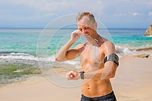 Man using wearable tech while running on the beach