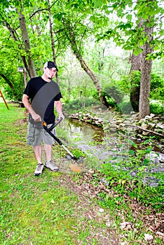 Man Using Weed Trimmer Smiling