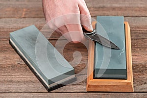 Man using a whetstone to sharp his pocket knife