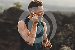 Man using wireless earphones air pods on running photo