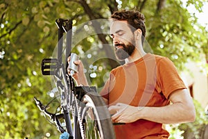 Man utilizing lubricant on bicycle