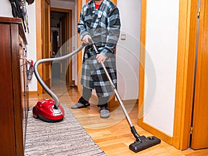 Man vacuuming at home during coronavirus alertness