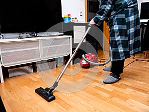 Man vacuuming at home during coronavirus alertness