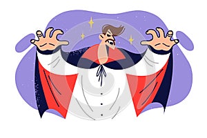 Man vampire celebrates halloween by eerily showing fangs dressed in robes of count Dracula