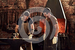 Man versus iron. two handsome young metal workers working together inside a welding workshop.