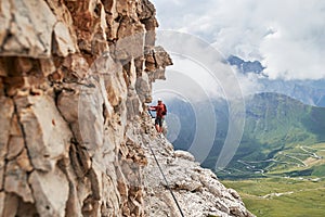 Uomo sul Attraverso dolomiti montagne, vicino sul la roccia parete avvolgimento strade sotto estate 