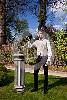 Man in Victorian clothing and sundial in the park