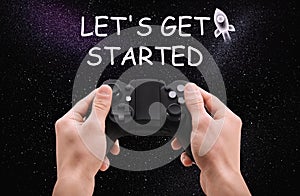 Man with video game controller and phrase LET`S GET STARTED against night sky