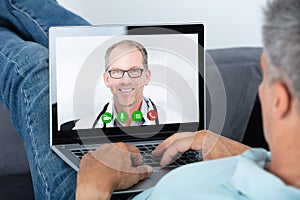 Man Videoconferencing With Doctor On Laptop