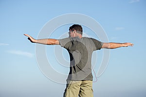 Man viewed from back stretches arms