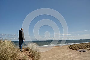 Man at a viewpoint overlooking a beach