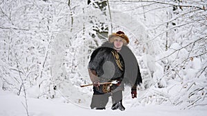 Man viking going in the winter forest.