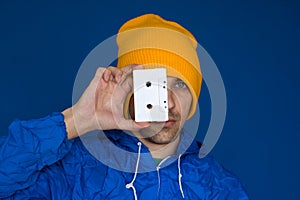 Man in vintage blue jacket and yellow hat with audio tape