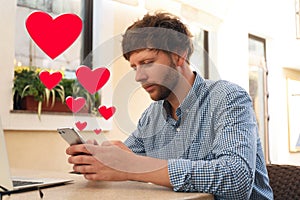 Man visiting dating site via smartphone in cafe