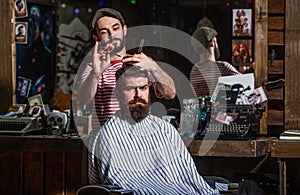 Man visiting hairstylist in barbershop. Barber scissors. Bearded man in barber shop. Work in the barber shop