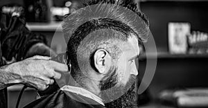 Man visiting hairstylist in barbershop. Barber works with hair clipper. Hipster client getting haircut. Black and white