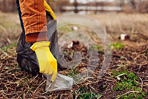 Man volunteer cleaning up the trash in park. Picking up rubbish outdoors. Ecology and environment concept