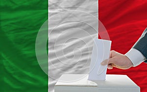 Man voting on elections in italy in front of flag photo