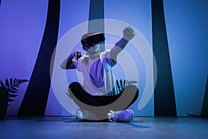 Man with VR glasses sitting on the virtual reality escape room floor