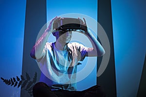 Man with VR glasses sitting on the virtual reality escape room floor