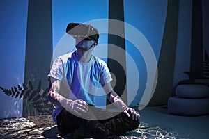 Man with VR glasses sitting on the virtual reality escape room floor