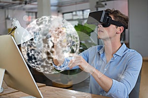 Man in VR headset touching a 3D sphere interface