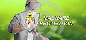 Man with VR headset touching a malware protection concept on a touch screen