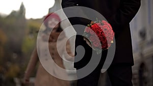 Man waiting for girlfriend, holding flowers, first date, beginning of relations