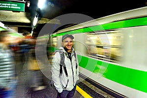 A man waits for the arrival of a train at a subway station in Milan