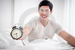 Man wake up and stop alarm clock with optimistic feeling