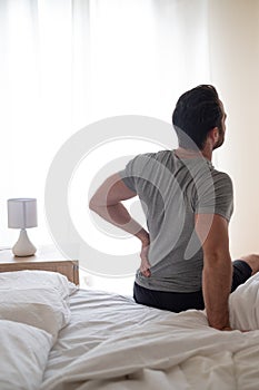 Man waking up in the morning and suffer for back pain