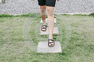 Man walk on concrete block pathway in green grass early autumn falling.Garden landscaping of walk way or pathway.high angle view o