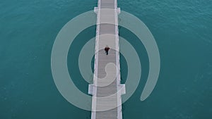 Man walk on infinity endless wooden pier or bridge