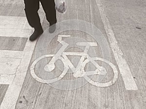The man walking above bicycle road sign .