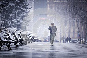 A man walking alone in a cold winter talking on the phone