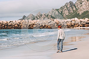 Man walking alone on empty beach traveling in Norway