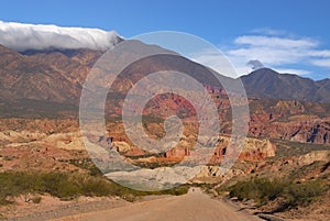 Man walking alone on a sand road with colorful background